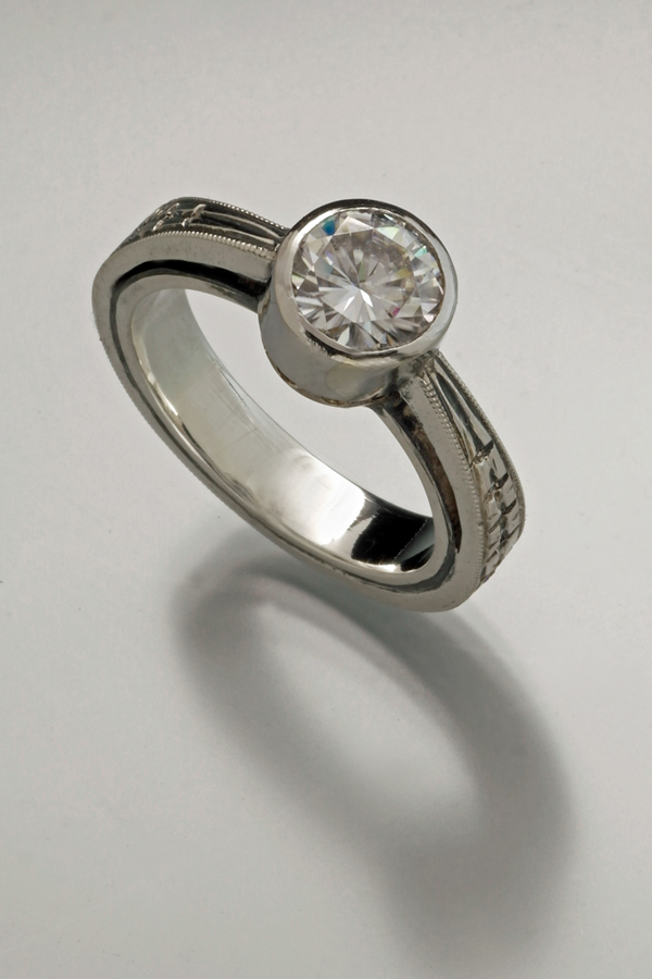 Forged and engraved ring in sterling silver & 14k gold with bezel set moissanite by Christoher Stephens